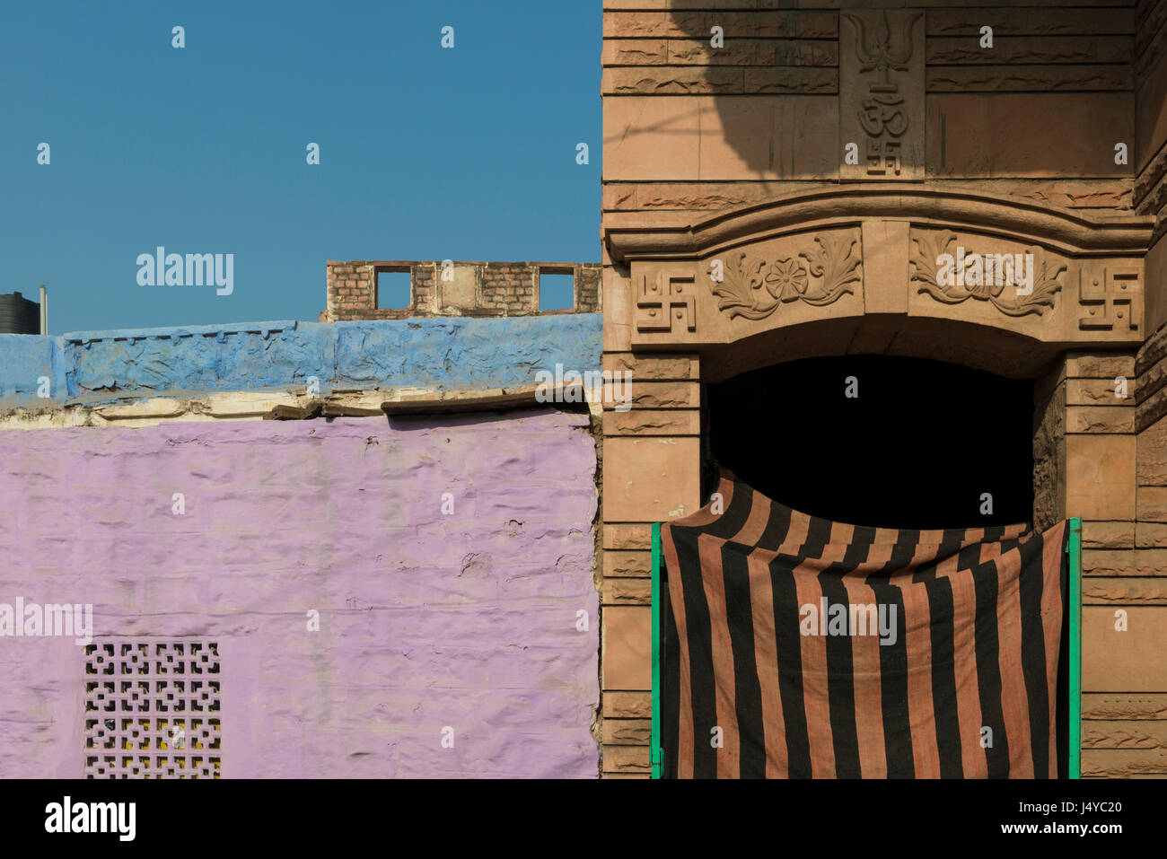 Religiöse Symbole ergänzen und betonen bunte städtische Landschaft von Jodhpur. Stockfoto