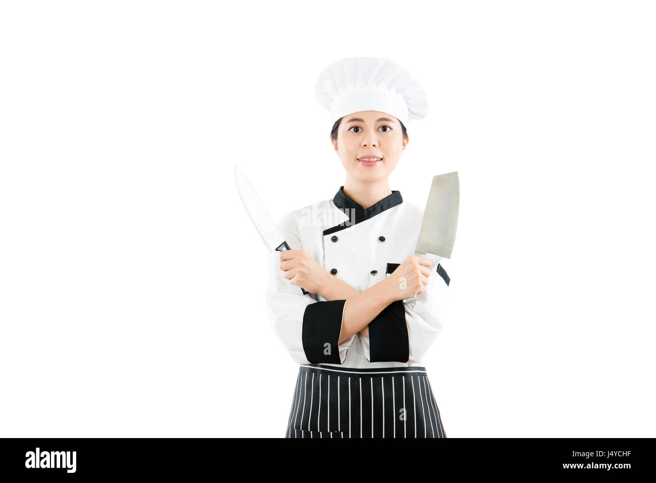 Profi-Koch zeigt zwei scharfe Messer mit Hände gekreuzt auf der Brust Stand vor der weißen Wand Hintergrund lächelndes Gesicht mit leeren Bereich ove Stockfoto