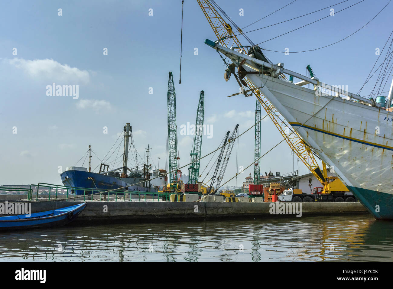 Sunda Kelapa Hafen mit alten Pinisi, Gegenüberstellung gegen eine moderne Frachter und Ladekrane, Jakarta, Indonesien. Stockfoto