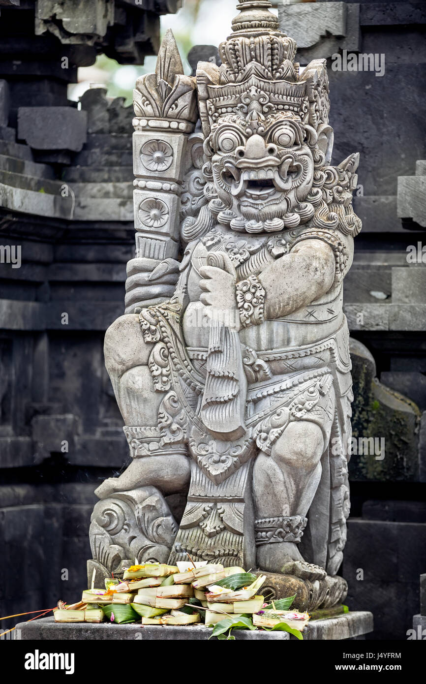 Skulpturen und Schnitzereien von Dämonen oder Götter mit Opfergaben in Ubud, Bali. Stockfoto