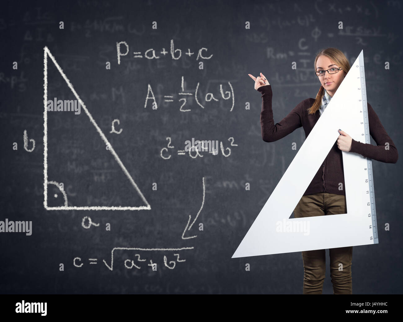 Studentin mit einem großen Lineal zeigt auf Pythagoras auf Tafel Stockfoto