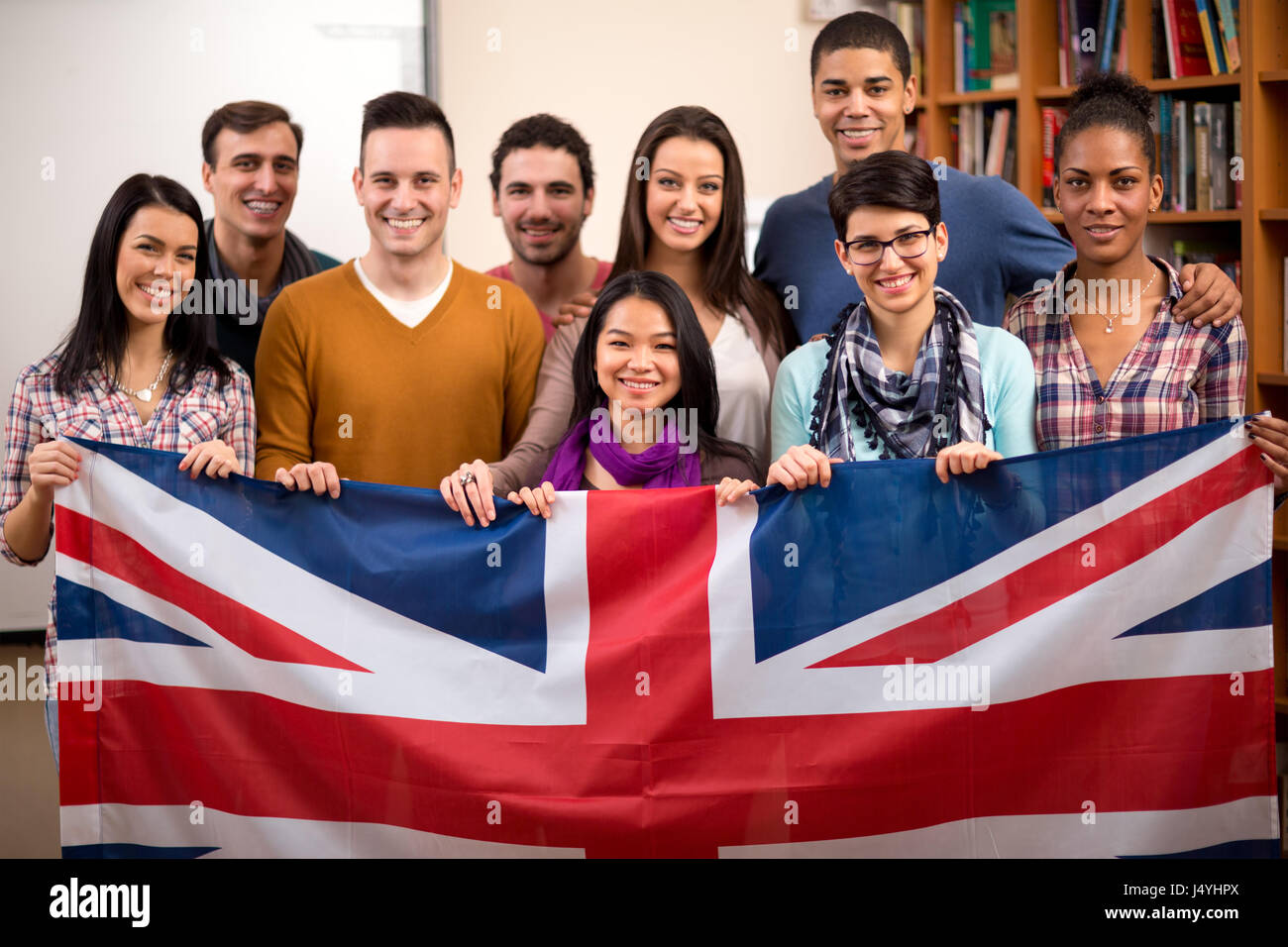 Gruppe von britischen Studenten präsentiert ihr Land und halten die Fahne Stockfoto