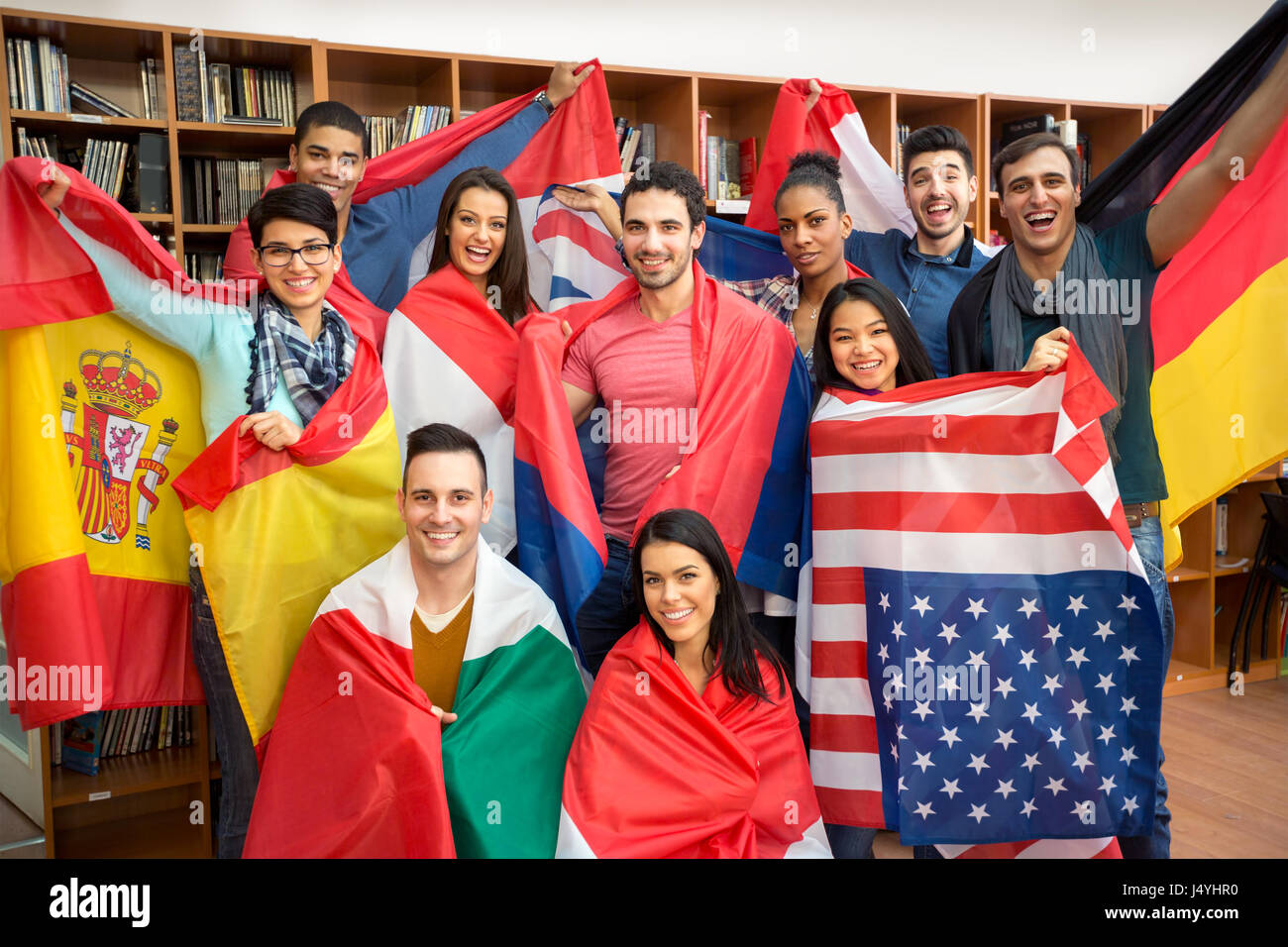 Internationalen multiethnischen Austausch von Studierenden, glückliche Schüler präsentieren ihre Länder mit Flaggen Stockfoto
