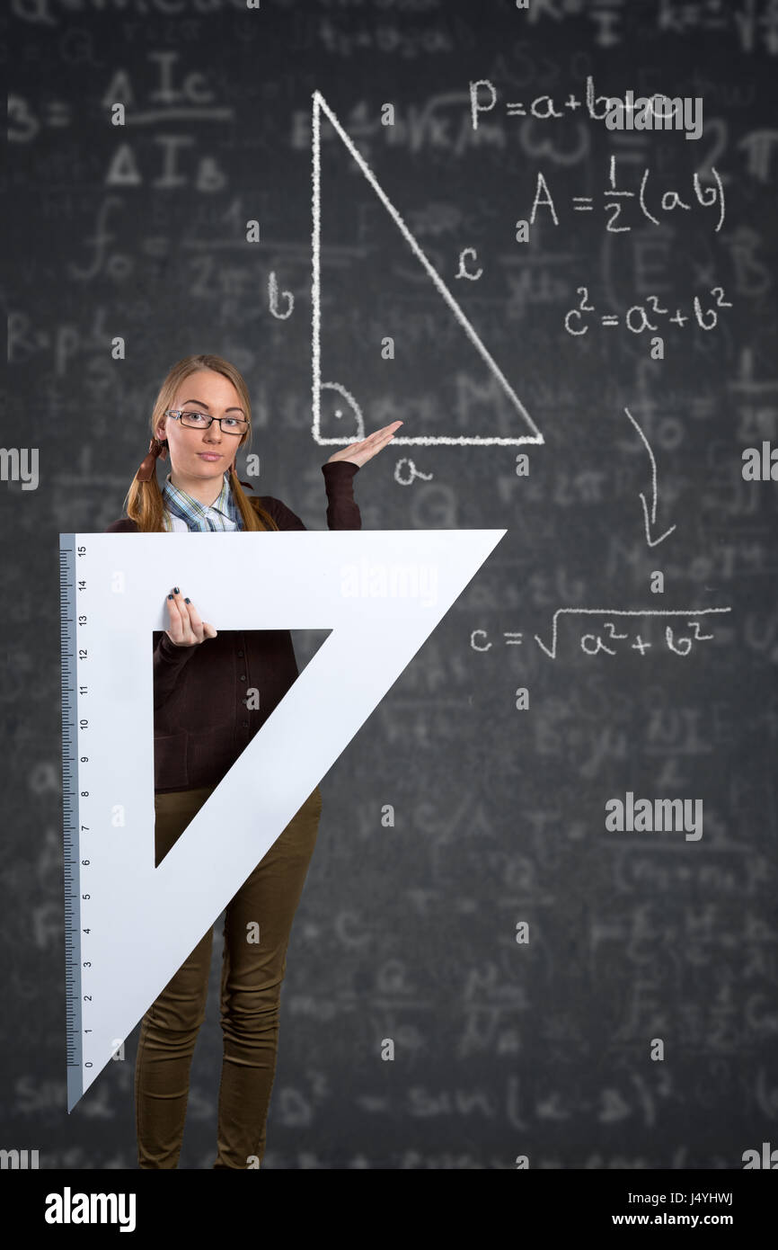 Studentin mit einem großen Lineal zeigt auf Pythagoras auf Tafel Stockfoto