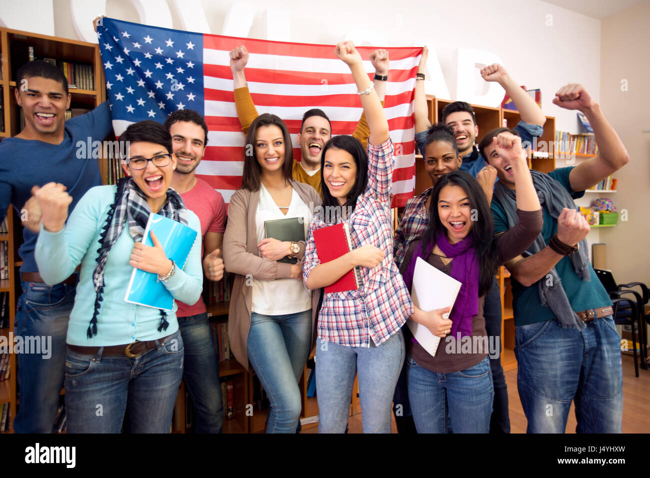 Lächelnd amerikanische Studenten präsentieren ihr Land mit Flaggen Stockfoto
