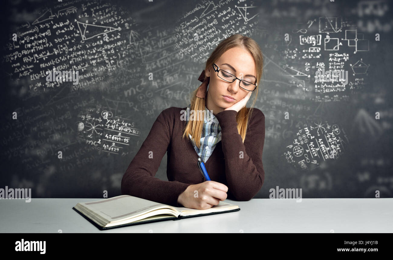 Denken Schüler sitzen an einem Schreibtisch und arbeiten-Mathe-Hausaufgaben Stockfoto