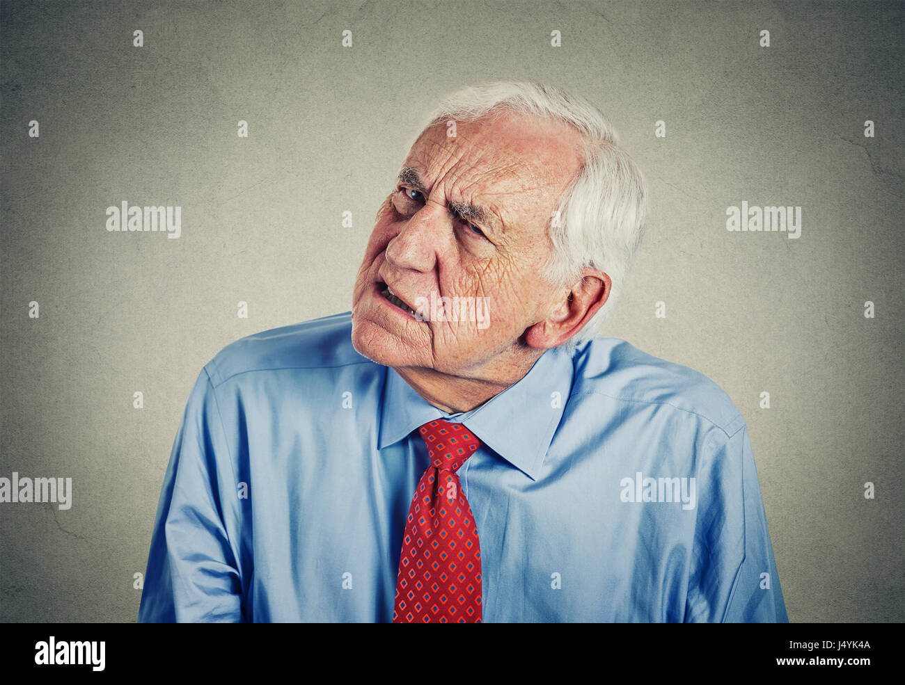 Closeup Portrait Kopfschuss senior Mann schwerhörig, jemanden zu sprechen hören nicht isolierte graue Wand Hintergrund. Stockfoto