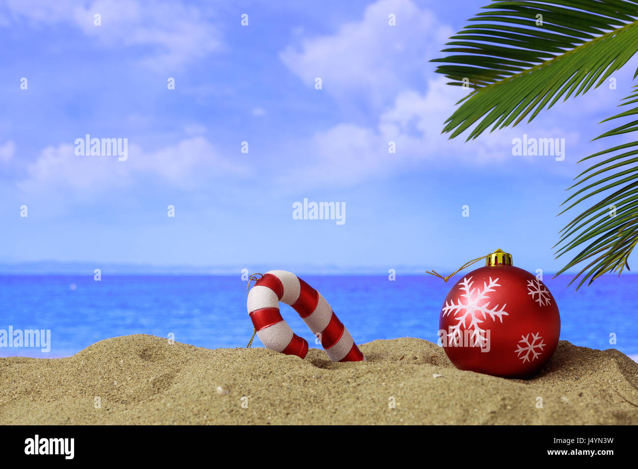 Weihnachtskugel und Ornament an einem Sandstrand - Textfreiraum Stockfoto