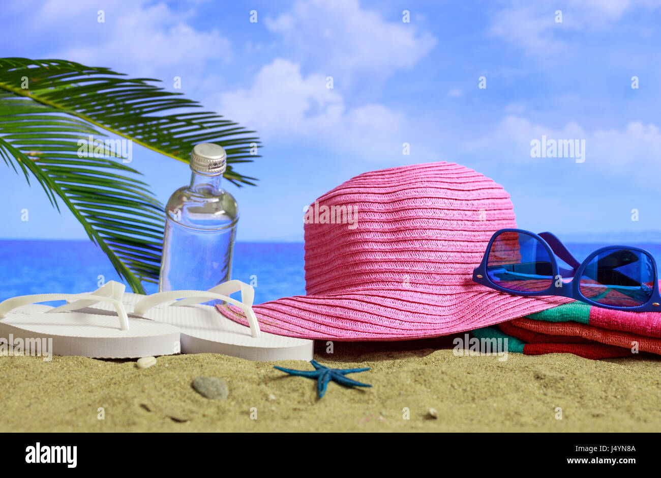 Sommerferien - Sonnenbrille und Hut an einem Sandstrand Stockfoto