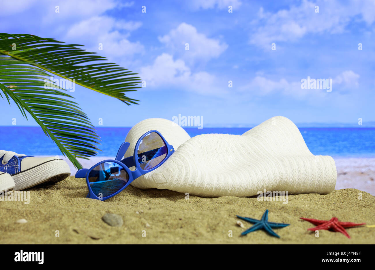 Sommer-Ferien-Konzept - Sonnenbrille und Hut an einem Sandstrand Stockfoto