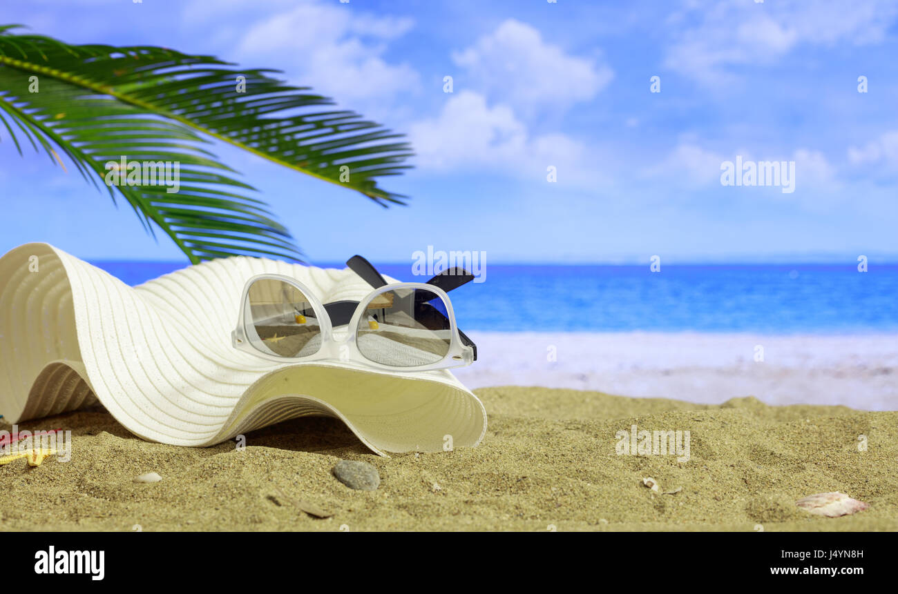 Sommer Urlaub Konzept - Sonnenbrille und Hut an einem Sandstrand - Textfreiraum Stockfoto