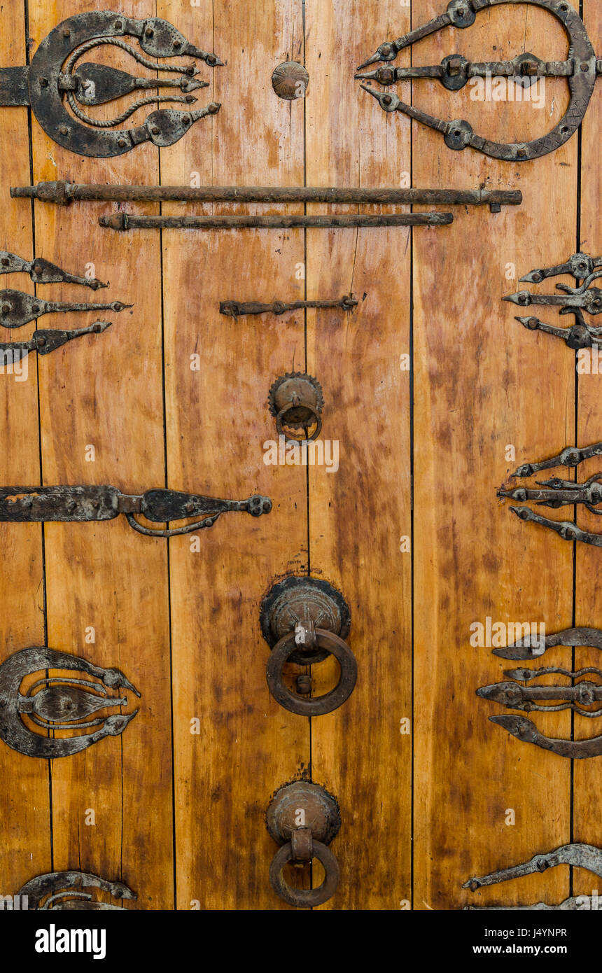 Alte Holztür mit Beschläge, Griffe und Ornamente im historischen Gebäude der alten arabischen Stadt Fes, Marokko. Stockfoto