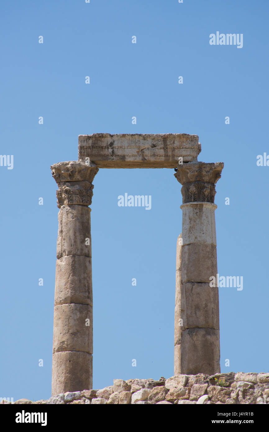 Nahaufnahme von Spalten der alten römischen Tempel des Herkules mit steinernen Balken oder Sturz auf geschnitzten Kapitellen auf der Zitadelle gegen einen tiefen blauen wolkenlosen Himmel. Stockfoto