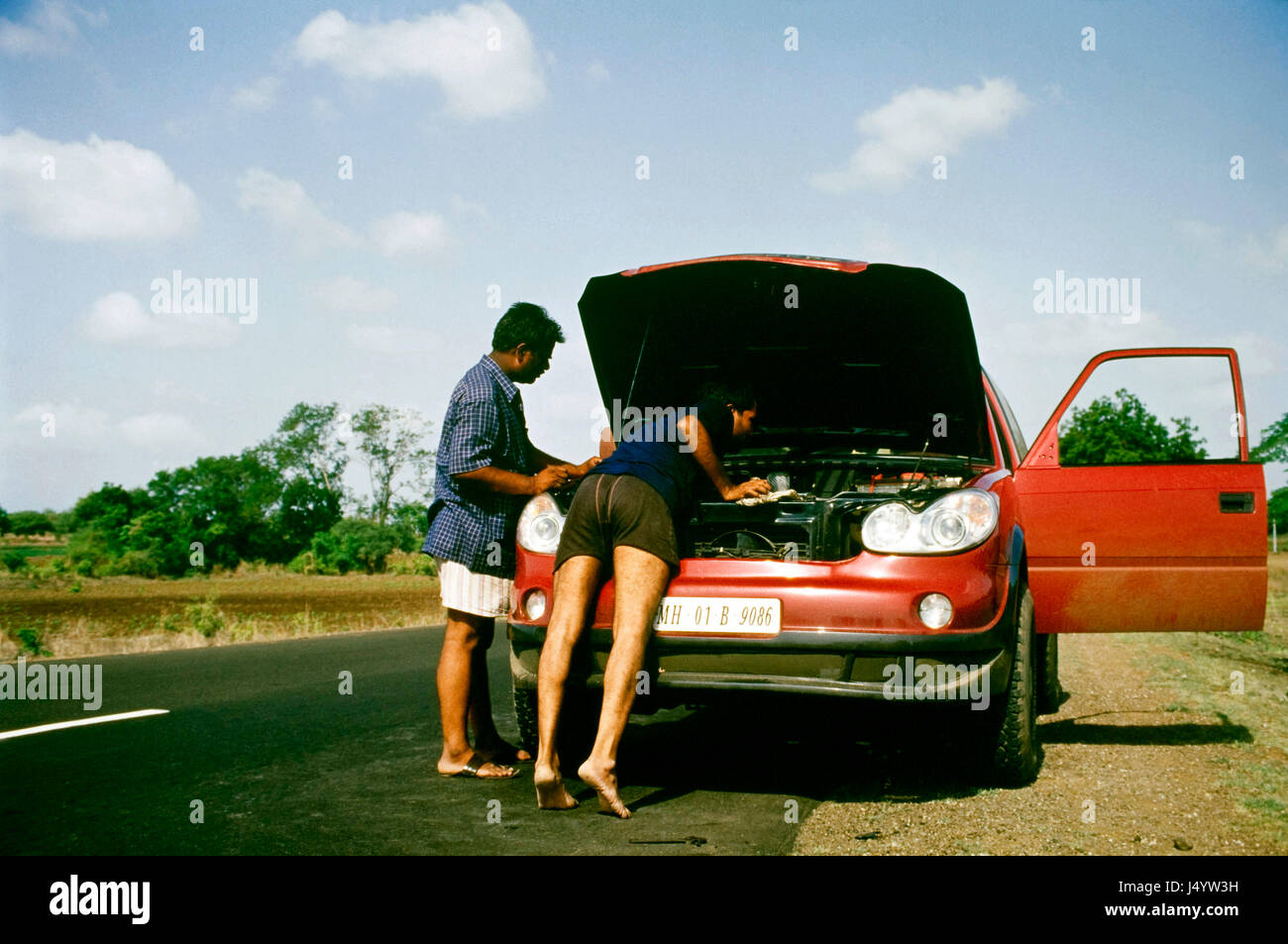 Mann, die Reparatur Autos auf der Straße, Indien, Asien Stockfoto