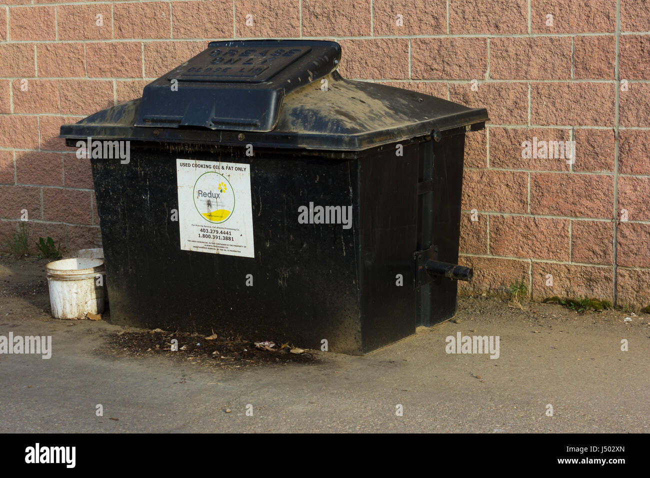 A verwendet Speiseöl Müllcontainer hinter einem Supermarkt. Stockfoto