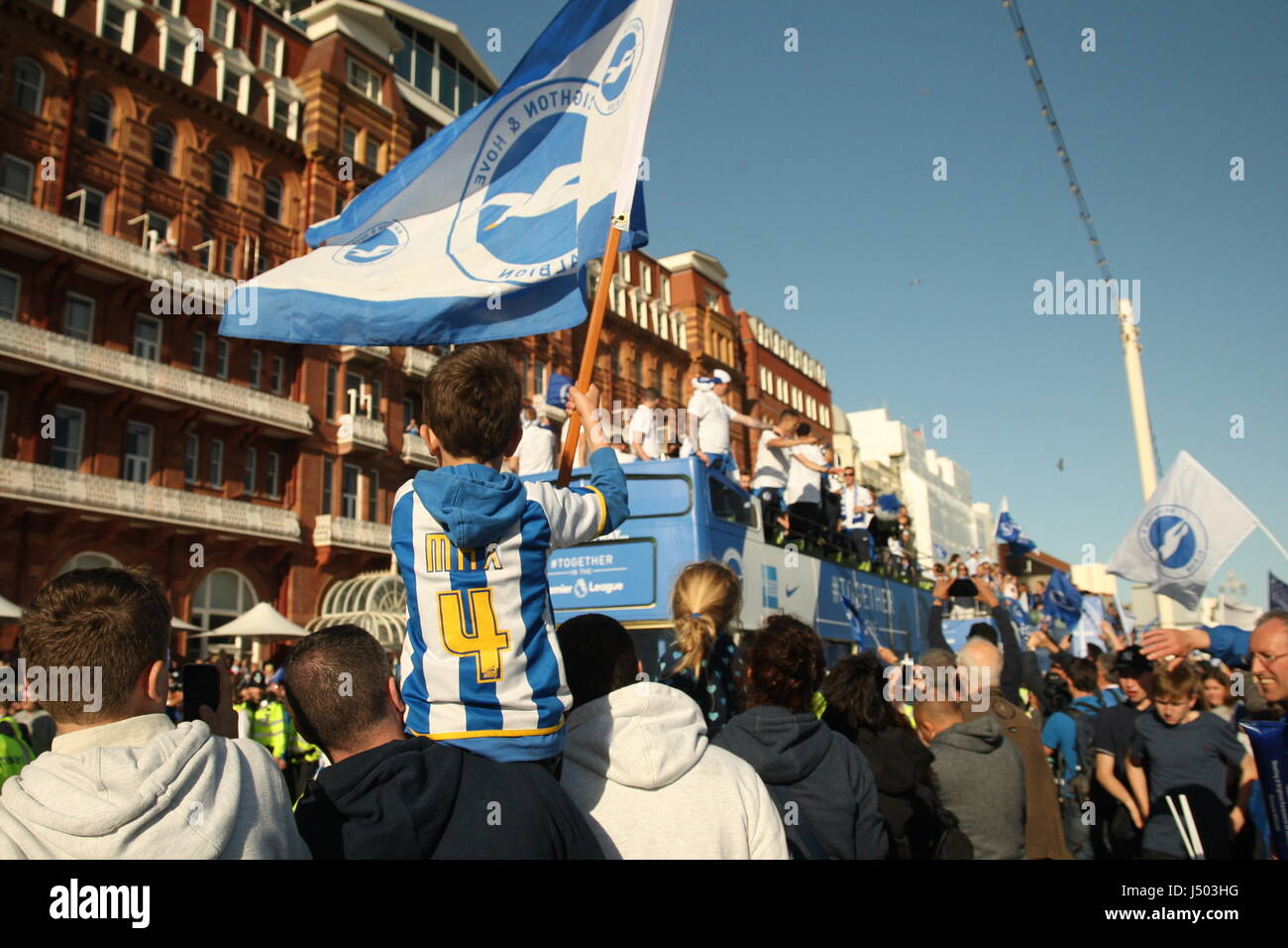 Brighton, UK. 14. Mai 2017.  Ein kleiner Junge fliegt eine Fahne mit Brighton und Hove Albion Farben drauf, beim Sitzen auf seines Vaters Schultern. Fans von Brighton und Hove Albion Football Club kam heraus in ihren Tausenden um das Team-Bus-Top Parade entlang der Stadt Küstenstraße. Mannschaft und Fans feierten Aufstieg in die Premier League. Roland Ravenhill / Alamy Live News Stockfoto