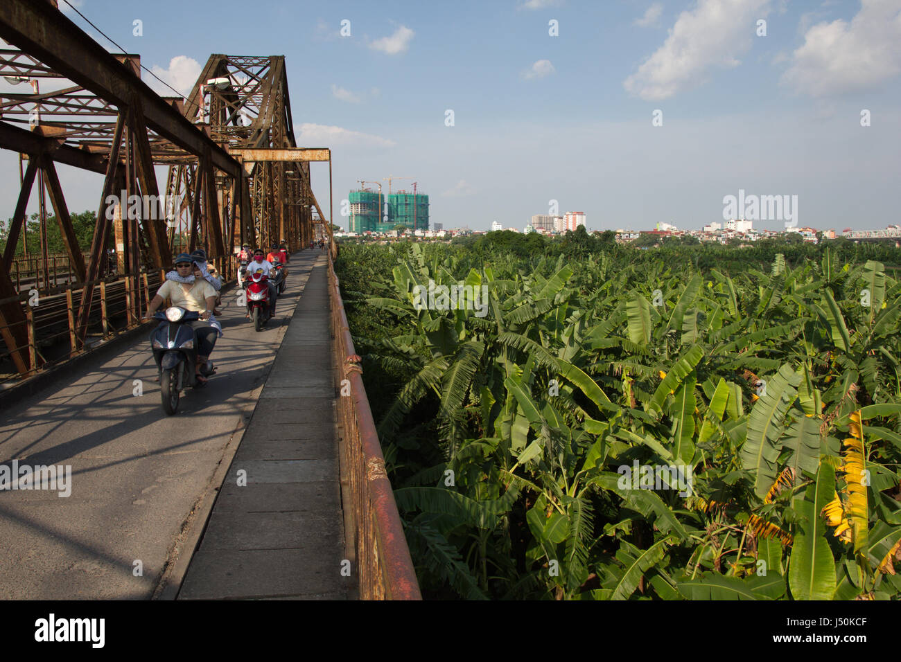 Die Franzosen errichtet Long Bien-Brücke führt über eine Bananenplantage auf einer Insel im Fluss "rot" in Hanoi, Vietnam Stockfoto