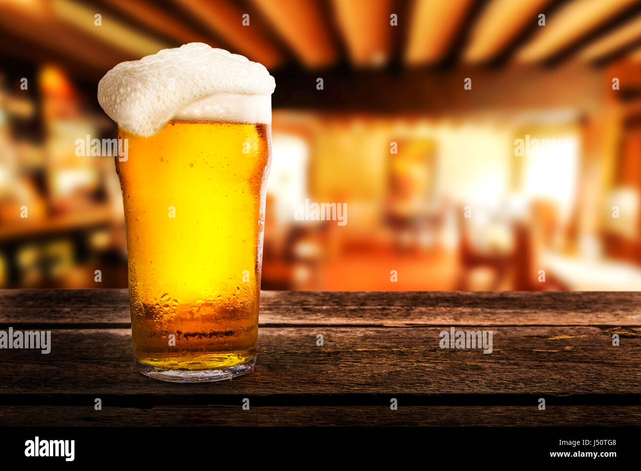 Glas helles Bier auf einem Tisch in einer Kneipe Stockfoto