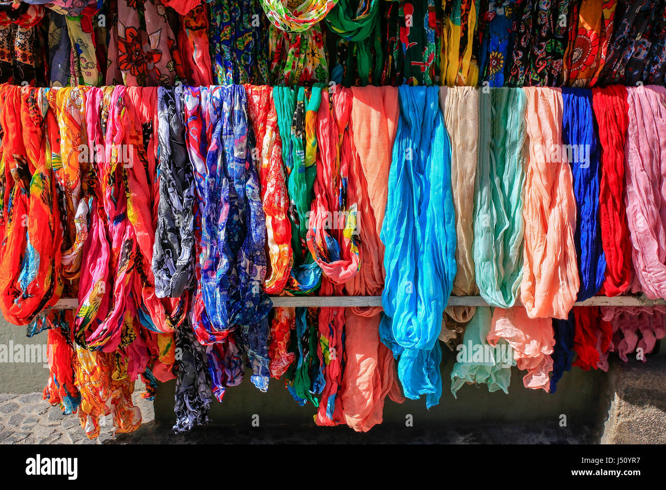 Viele bunte Schals hängen zum Verkauf auf Markt Stockfoto
