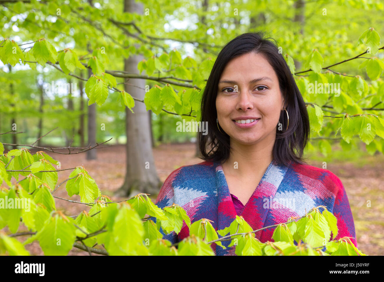 Porträt kolumbianische Frau mit grünen Blätter im Frühling Stockfoto