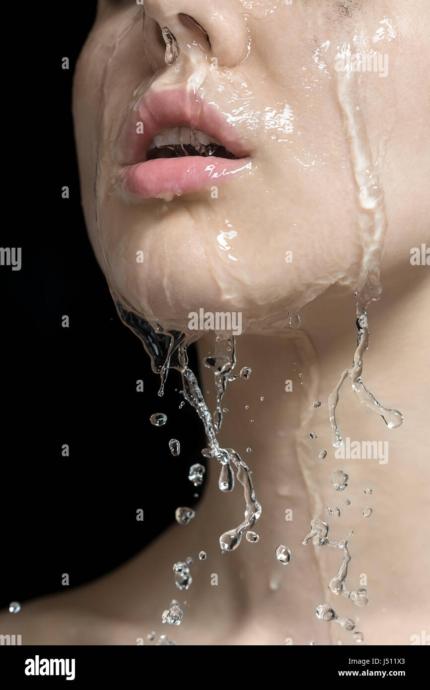Wasser spritzt auf Frau ins Gesicht Stockfoto