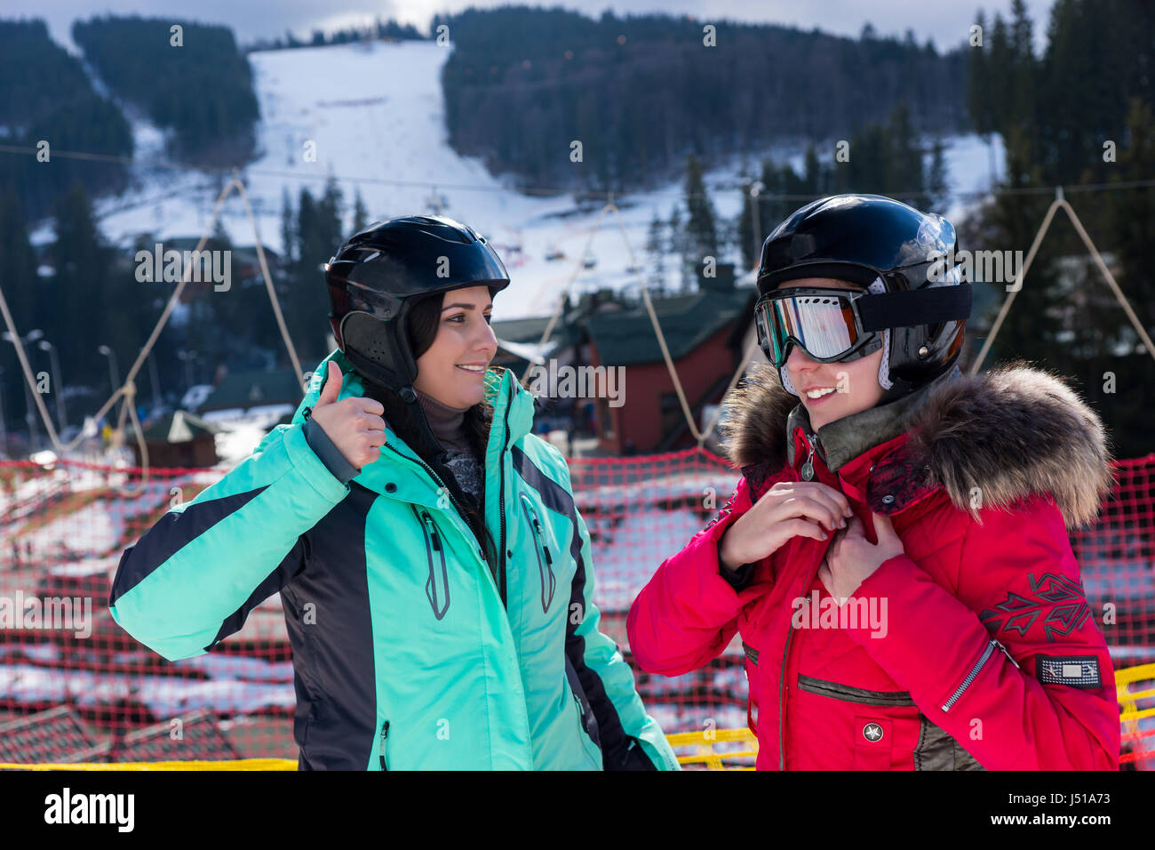 Junge Frauen in Ski-Anzüge, Helme und Skibrillen stehend in einem Skigebiet im Winter Stockfoto