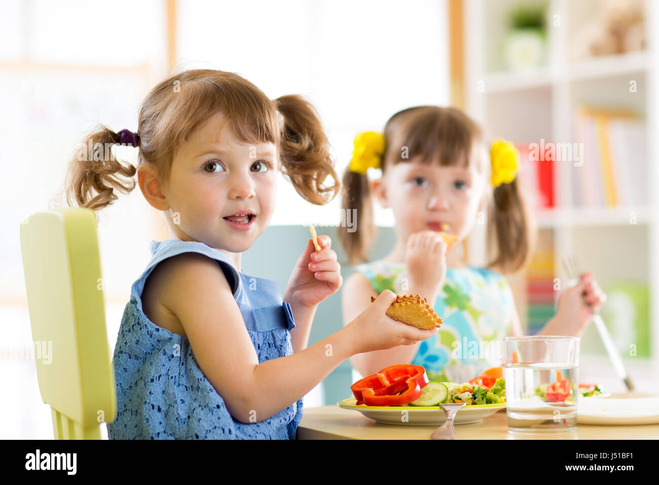 Kinder Essen von Tellern in Kindertagesstätte Stockfoto