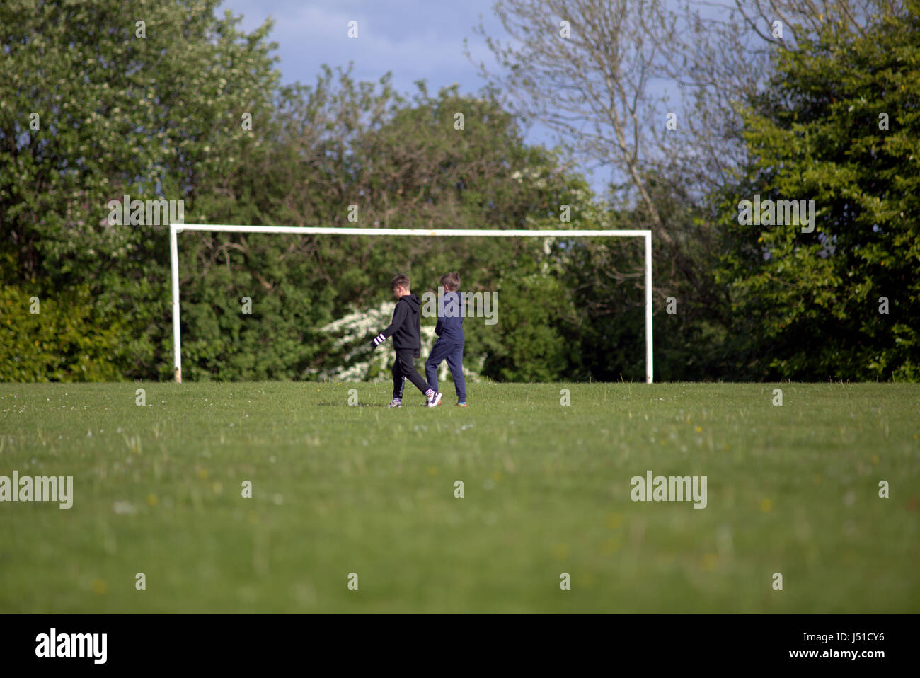 Blairdardie Park keal Avenue zwei kleine Jungen, die über Fußball laufen Fußballplatz grün Gras Kindheit Freundschaft Stockfoto
