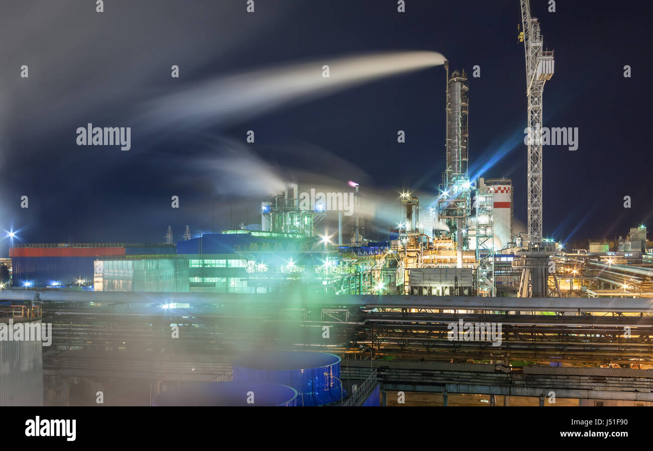 Dampf aus dem Kühlturm vor dem Hintergrund einer Pipeline und ein Chemiewerk in der Nacht Stockfoto