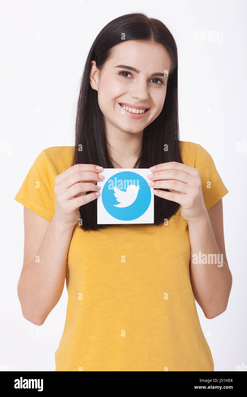 Kiew, UKRAINE - 22. August 2016: Frau Hände halten Twitter Logo Icoi Vogel bedrucktes Papier. Twitter ist ein social Networking-Onlinedienst, mit dem Benutzer senden und Lesen von SMS-Nachrichten. Stockfoto