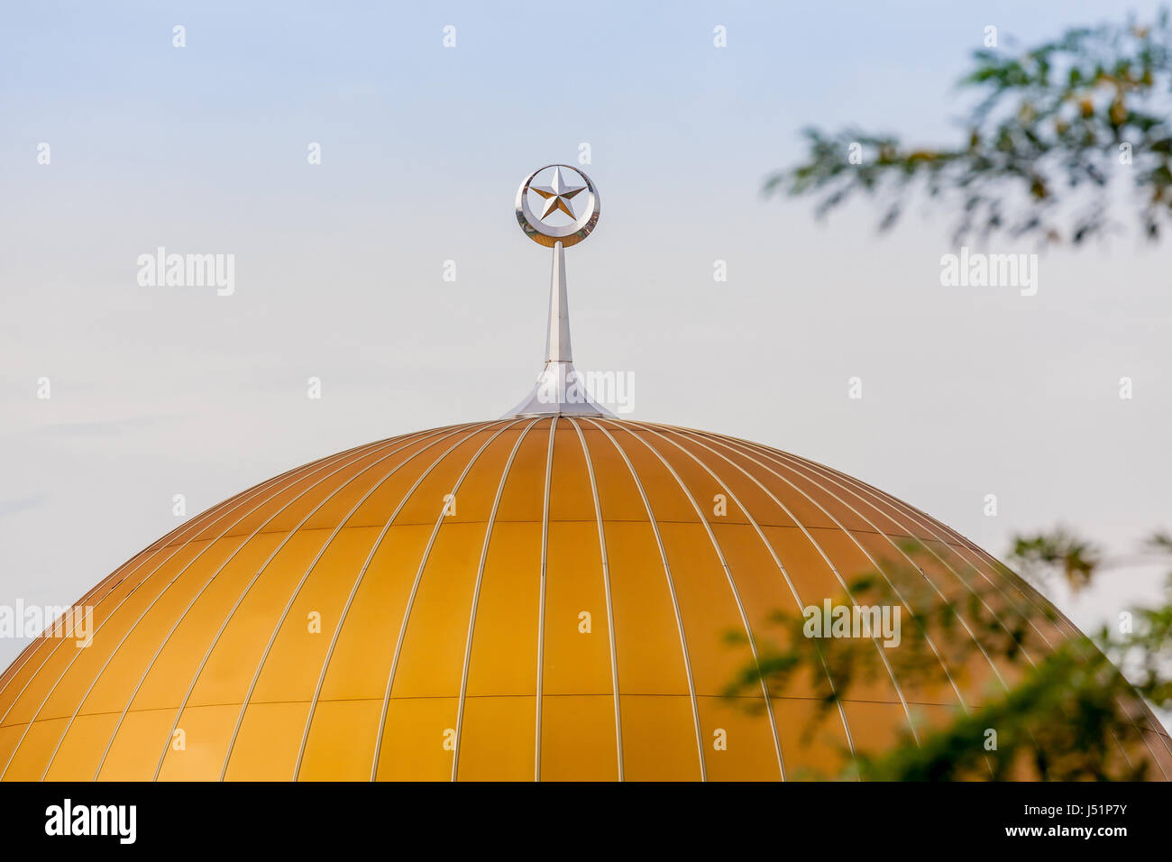 Ein silberner Stern und Halbmond steht am Anfang die orange Kuppel einer islamischen Moschee in Petaling Jaya, Selangor, Malaysia, Südost-Asien. Stockfoto