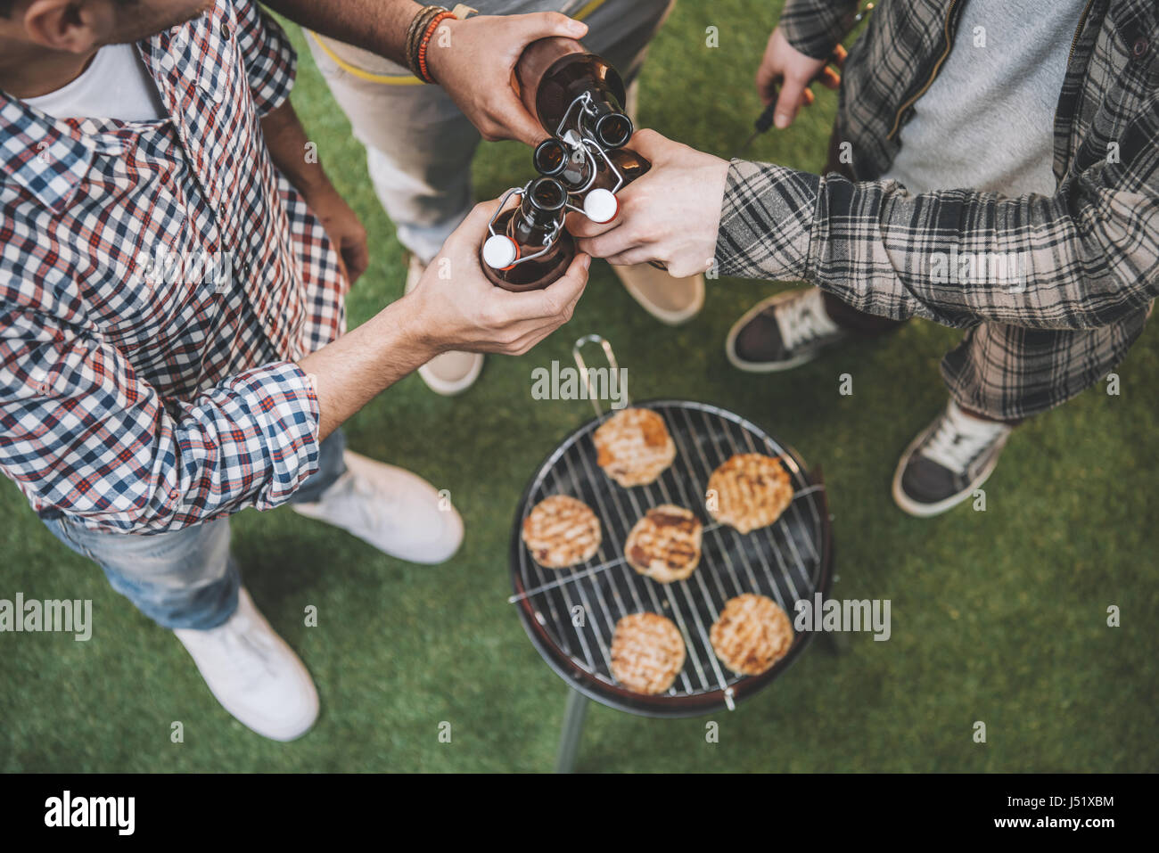 Draufsicht der jungen Freunde, trinken Bier und Grill zu machen Stockfoto