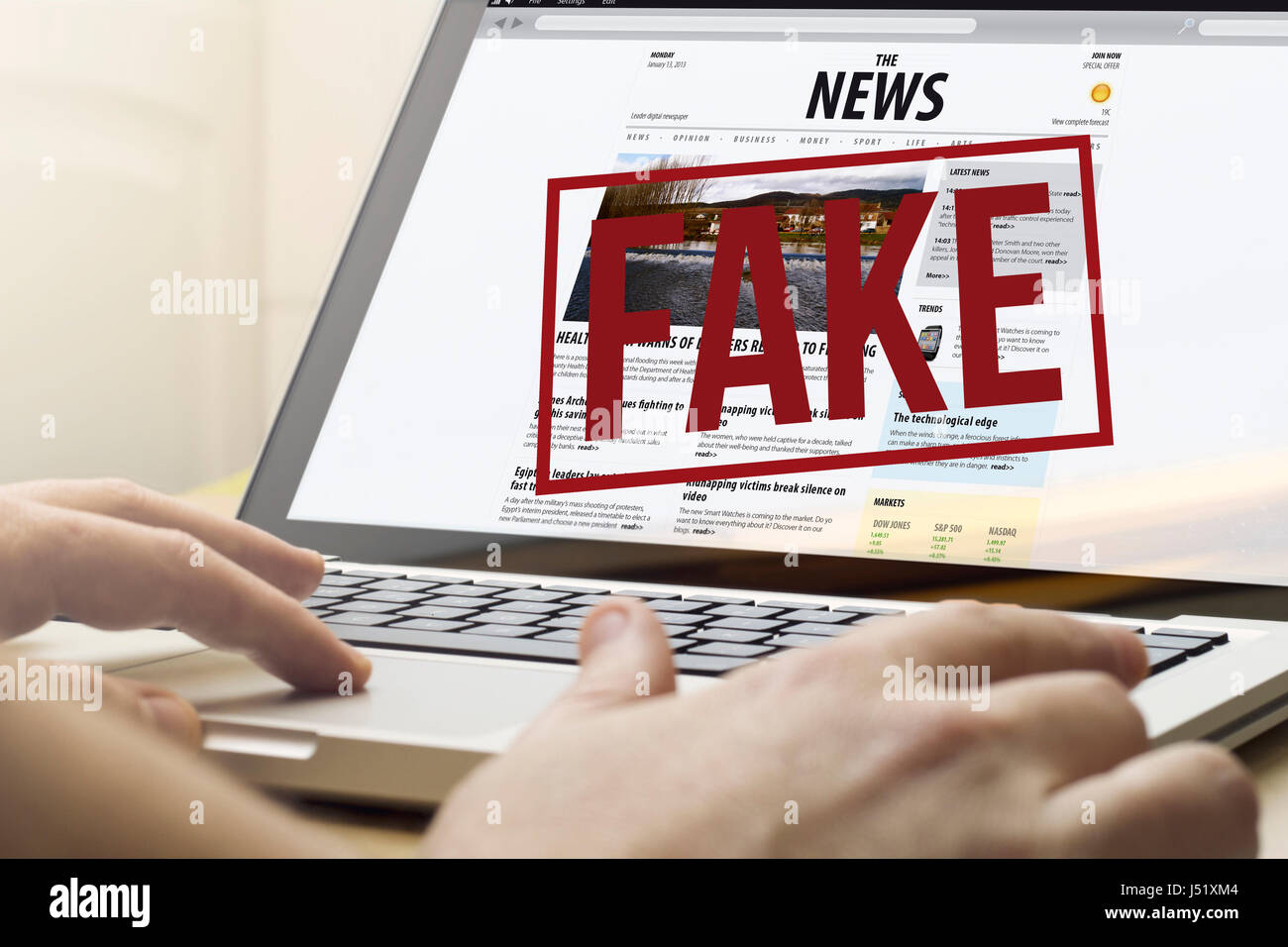 Home-computing-Konzept: Mann mit einem Laptop, um gefälschte Nachrichten zu lesen Stockfoto