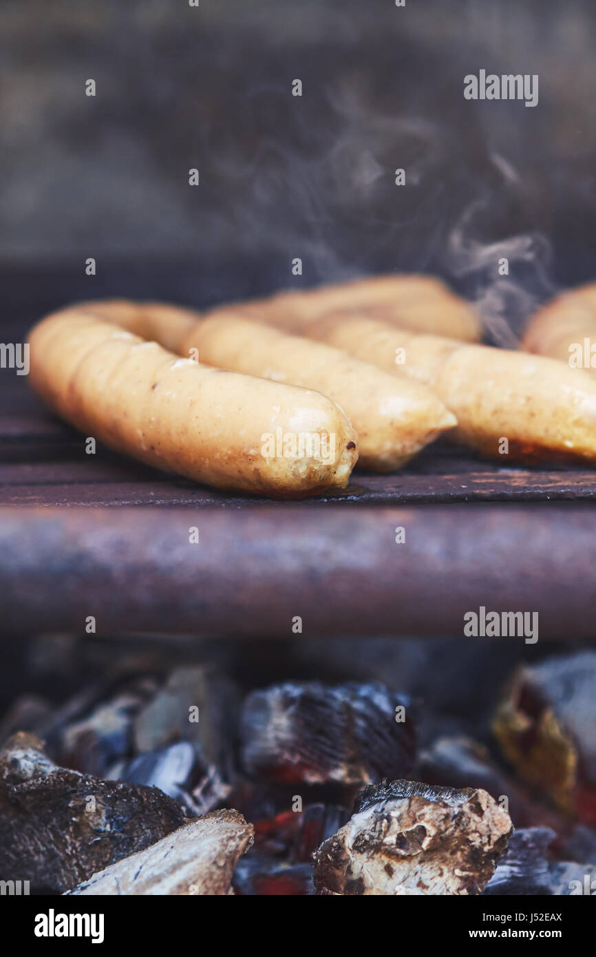 Würstchen auf Grill mit Rauch und Holzkohle. Textfreiraum Stockfoto