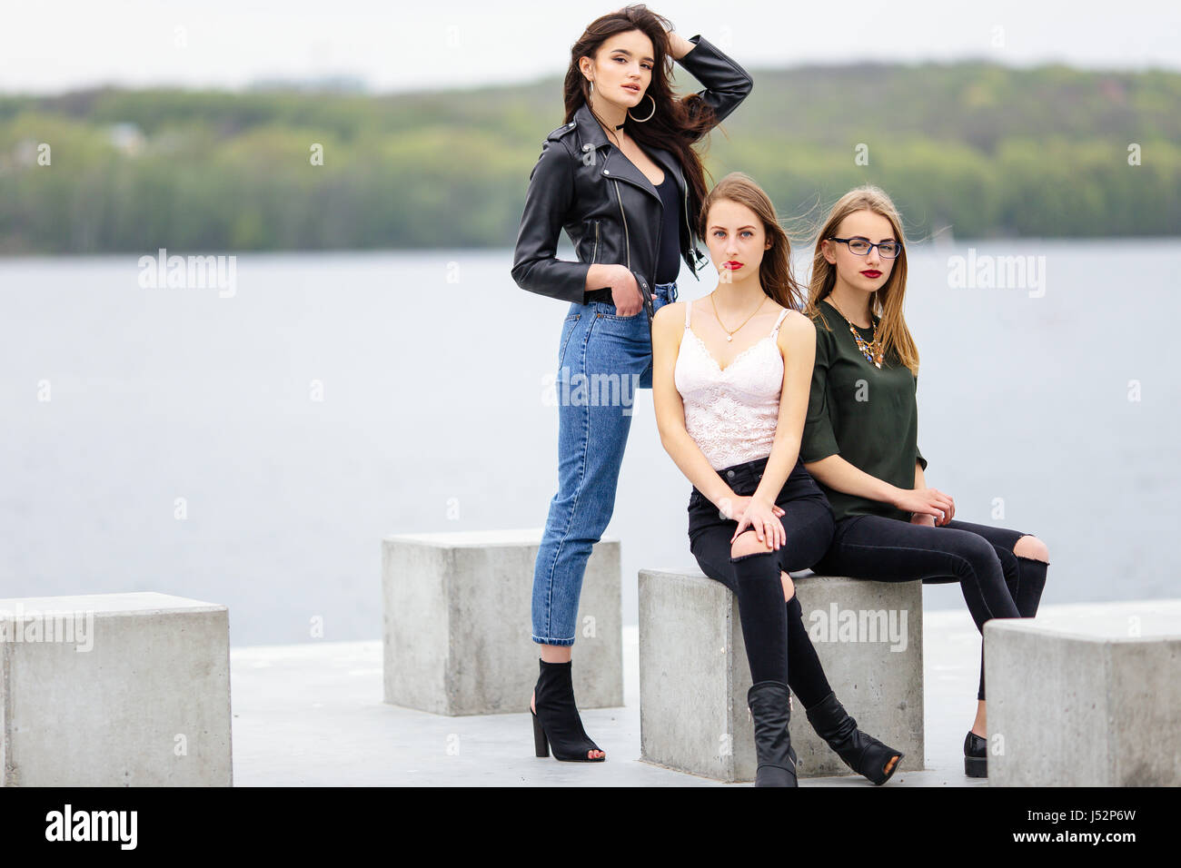 Zwei Mädchen sitzen auf Bank mit einem Ständer in der Nähe von sie, stellen für Kamera Stockfoto