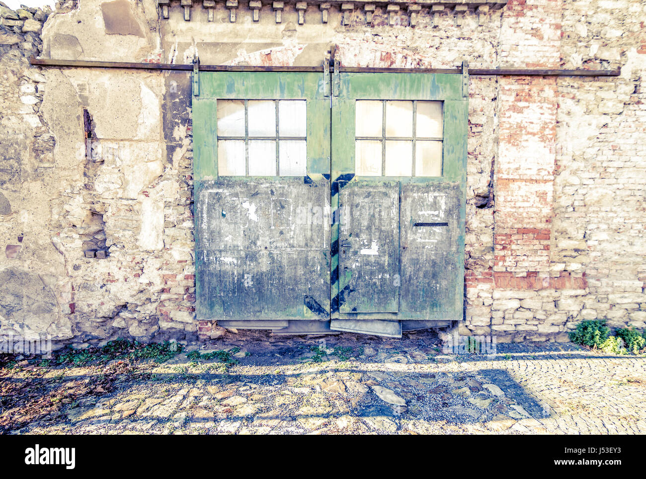 Große alte Lager Tür mit grünen Farbe auf Ziegelwand peeling. Stockfoto