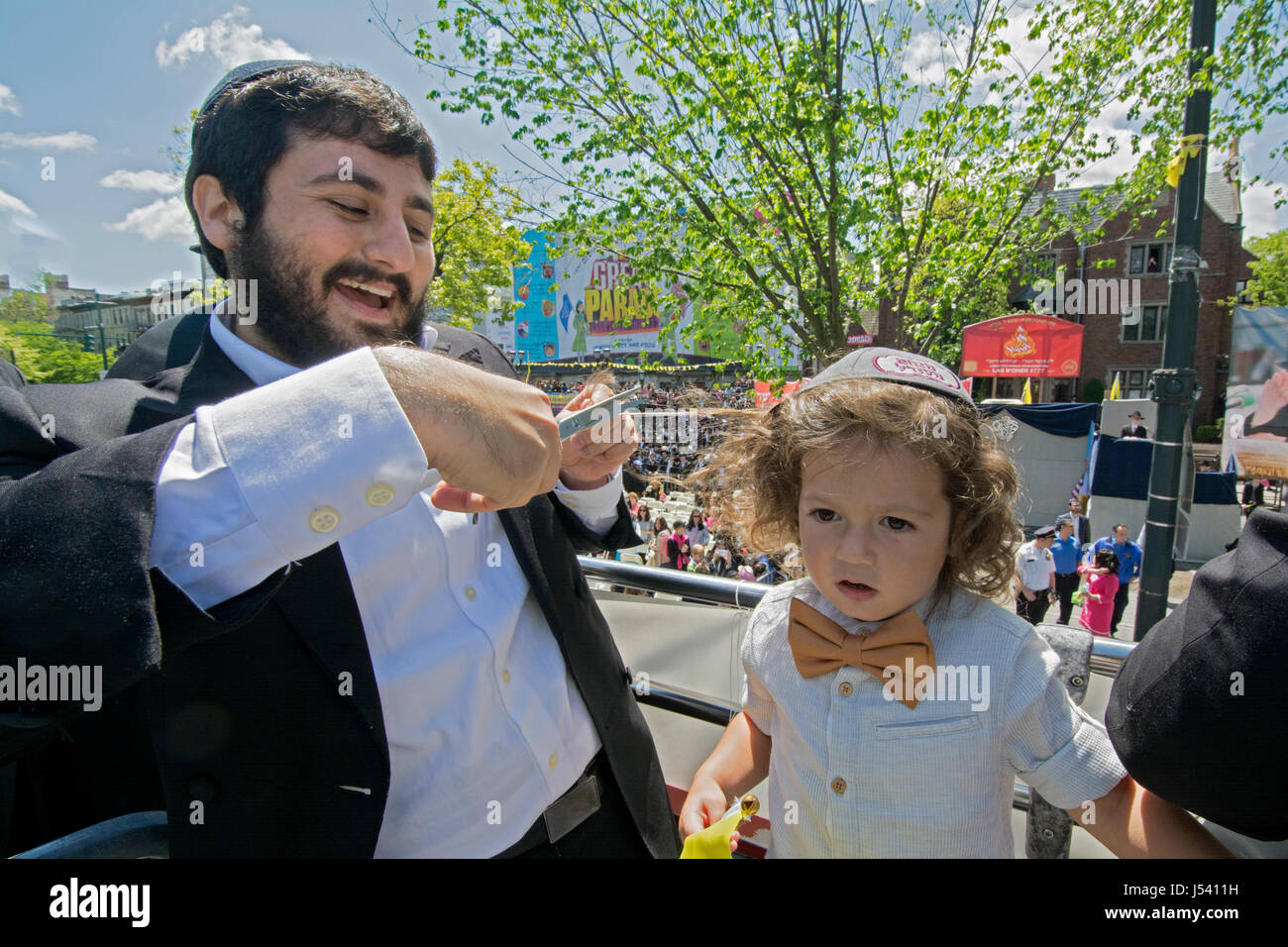 5.14.2017 bekommt ein orthodoxen jüdischen Jungen seinen ersten Haarschnitt an Alter drei bei der Verzögerung B'Omer Parade in Crown Heights, Brooklyn, New York City Stockfoto