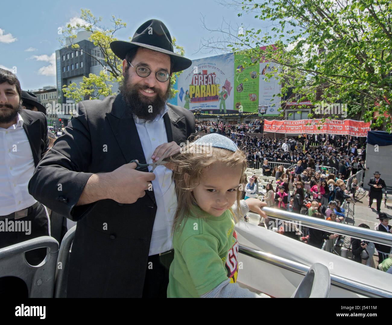 5.14.2017 bekommt ein orthodoxen jüdischen Jungen seinen ersten Haarschnitt an Alter drei bei der Verzögerung B'Omer Parade in Crown Heights, Brooklyn, New York City Stockfoto