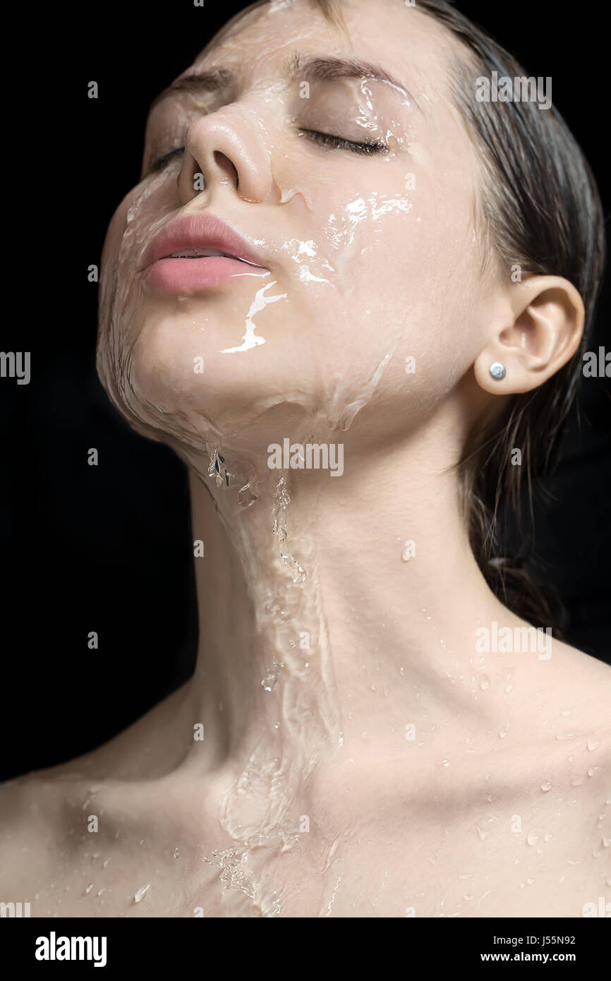 Wasser spritzt auf Frau ins Gesicht Stockfoto