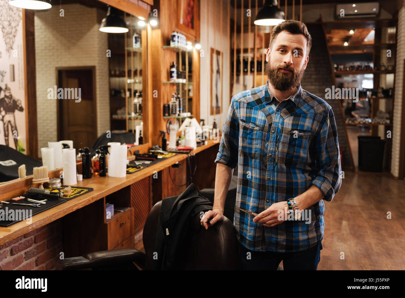 Schön schön Friseur stehen in der Nähe seines Arbeitsplatzes Stockfoto