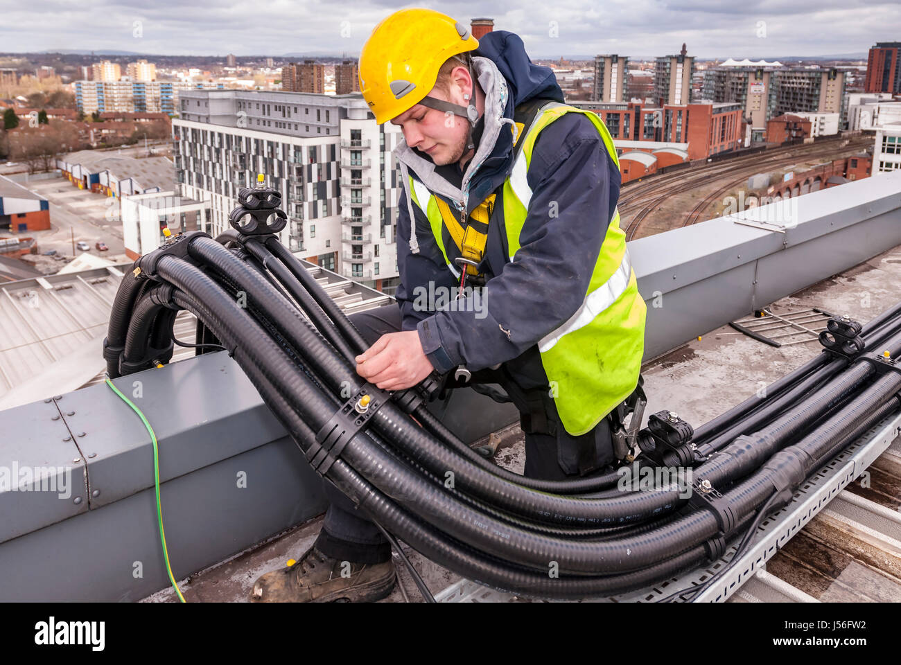 Arbeiter, die Fixierung von Leitungen auf einem Dach für Handy-Geräte. Stockfoto