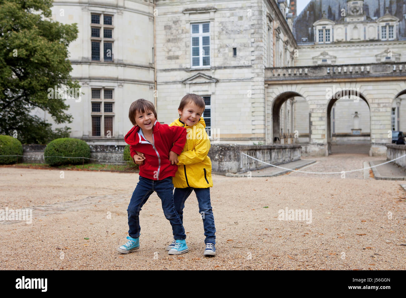 Zwei Kinder spielen im Regen vor dem Le Lude-Schloss in Frankreich Stockfoto