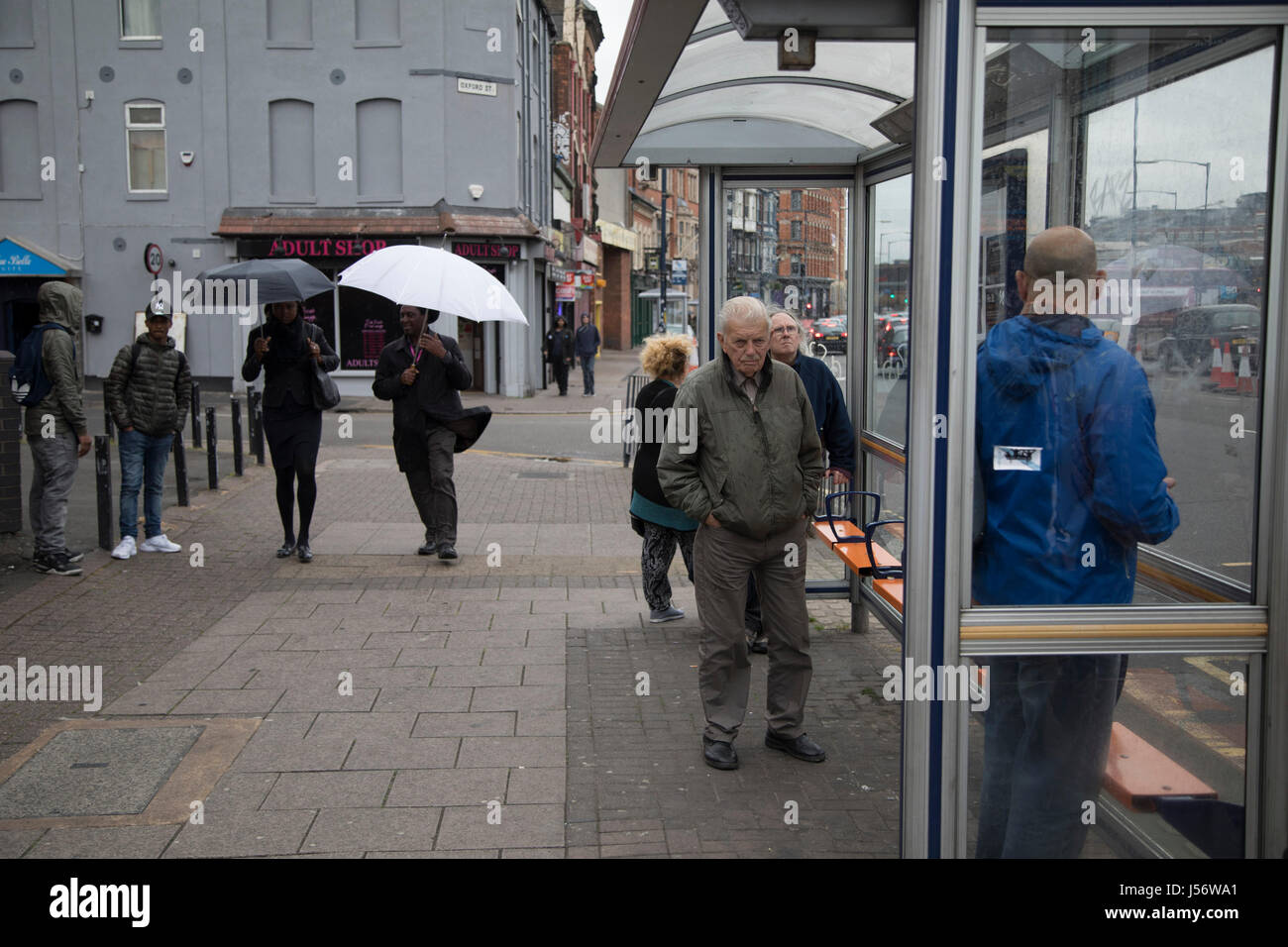 Straßenszene von Menschen an einer Bushaltestelle in Digbeth, Birmingham, Vereinigtes Königreich. Digbeth ist eine Fläche von Zentrum von Birmingham, England. Nach der Zerstörung der inneren Ringstraße gilt Digbeth heute ein Viertel im Stadtzentrum von Birmingham. Als Teil der großen Stadt-Plan durchläuft Digbeth eine große Sanierung-Regelung, die alten Industriegebäude in Wohnungen, Einzelhandelsflächen, Büros und Kunst Einrichtungen regenerieren wird. Es gibt noch sosehr Industriekonjunktur im Süden des Gebiets. Als Teil der Pläne Digbeth Coach Station wurde ebenfalls saniert und Birmi umbenannt Stockfoto