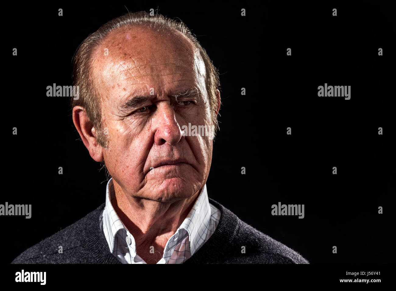 Opa wird ernst. Alter Mann sieht mit wütendes Gesicht auf schwarzem Hintergrund Stockfoto