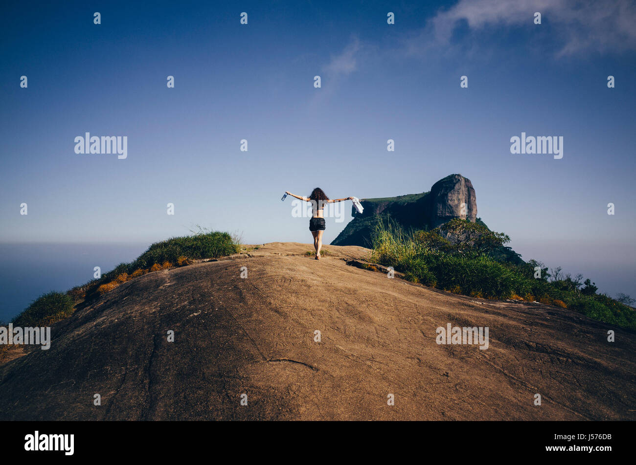 junge freigeistigen Frau genießt den Wind am Pedra Bonita Berg in Rio De Janeiro, Brasilien Stockfoto