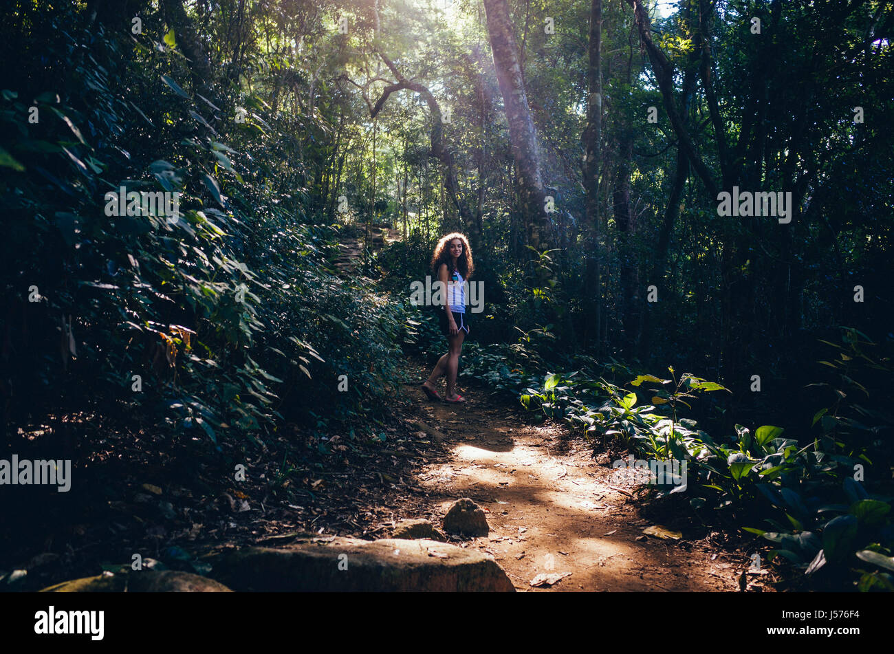 Junge Frau auf einem Trail im tropischen Regenwald von Rio De Janeiro, Brasilien Stockfoto