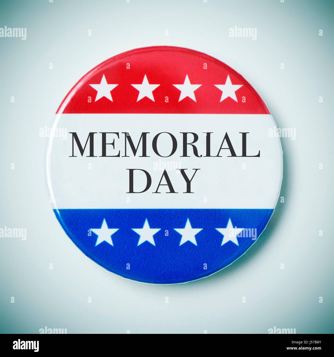 Nahaufnahme einer Pin-Schaltfläche mit dem Text Memorial Day und der Farben und Sterne der Flagge der Vereinigten Staaten, mit einer Vignette hinzugefügt Stockfoto