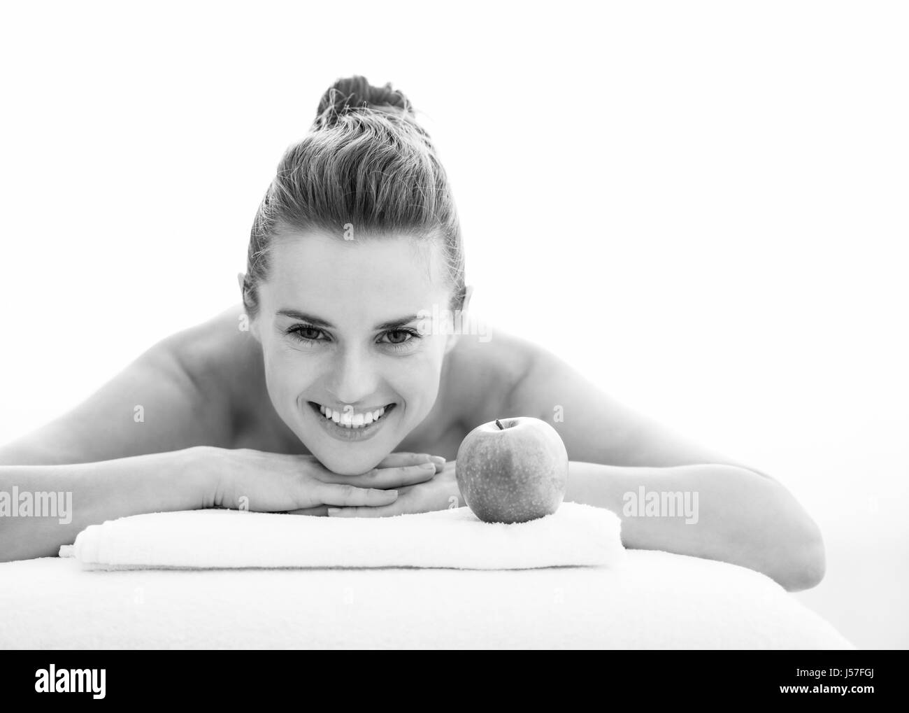 Porträt der lächelnde junge Frau mit Apfel Verlegung auf Massagetisch Stockfoto