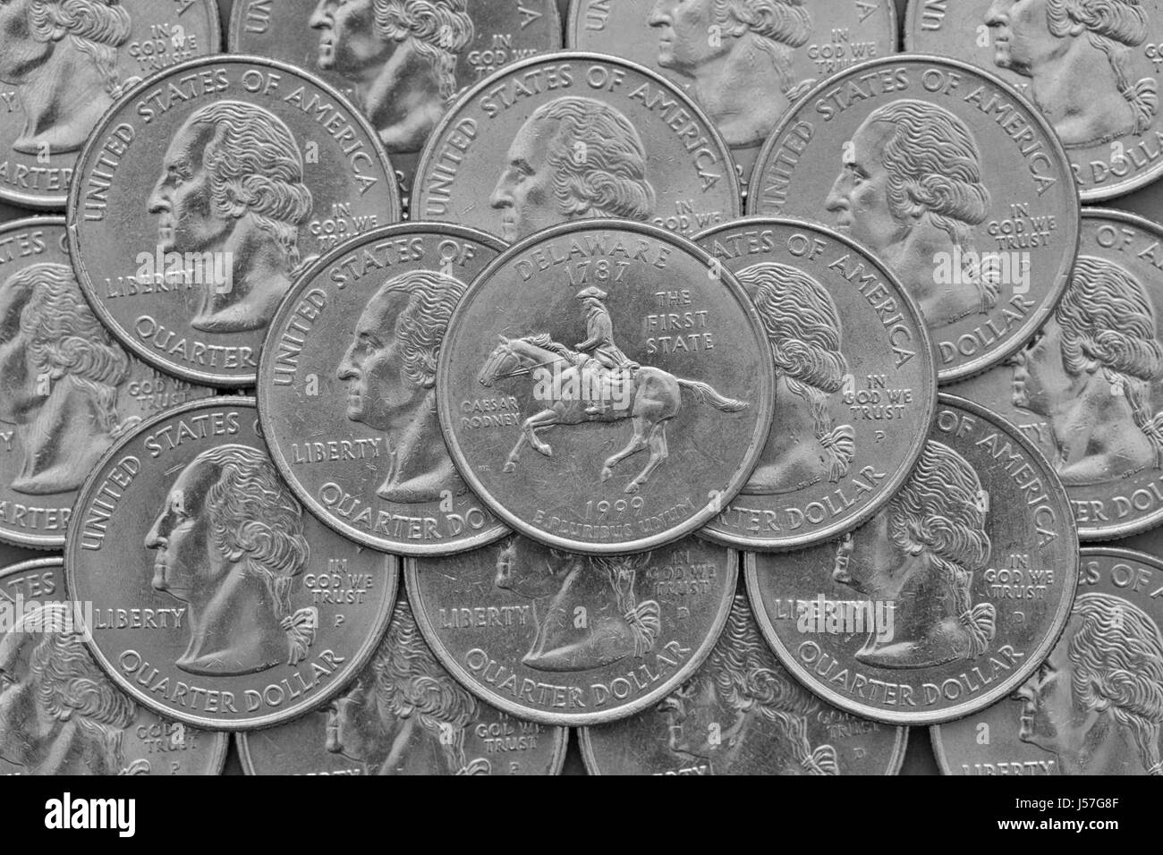 Delaware State und Münzen der USA.  Haufen von Quartier US Münzen mit George Washington und auf der Oberseite eine Viertel des Staates Delaware. Stockfoto