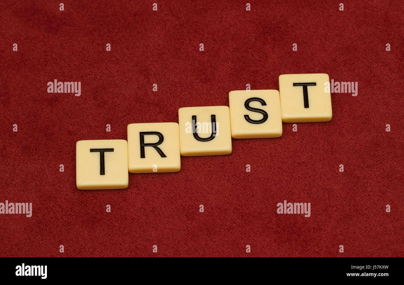 Vertrauen Sie Zeichen. Loyalität-Konzept. Elfenbein Fliesen mit großen Buchstaben auf rotem Velours. Stockfoto